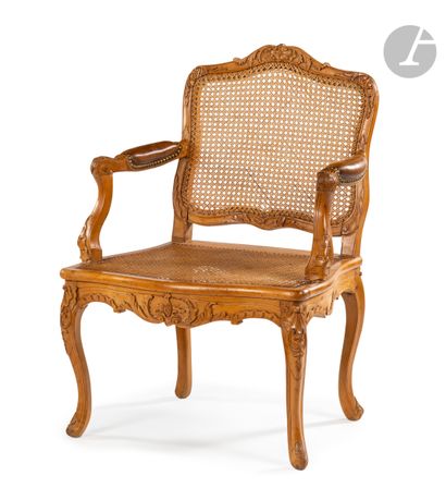  A molded and carved beechwood armchair with a flat cane back, decorated with rocaille,...