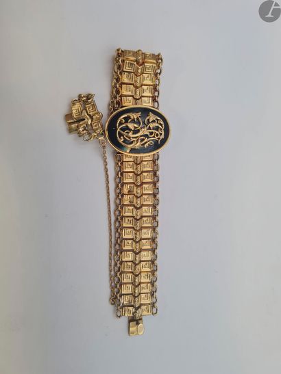  Bracelet souple en or (18K) centré d'un motif oval émaillé noir chiffré. Poids brut...