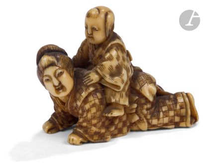null 
Netsuke en ivoire représentant un enfant jouant assis sur le dos d’une jeune...