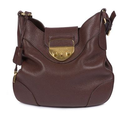 null PRADA. Brown grained leather bag, gilded metal trim, key under bell, in its...