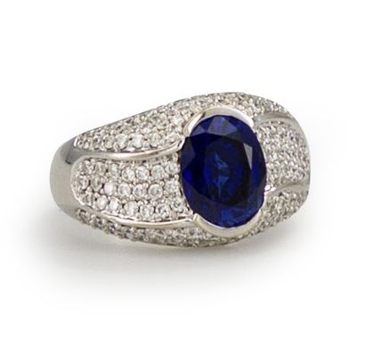 null 18K (750) white gold ring, set with an oval synthetic sapphire, paved with round...