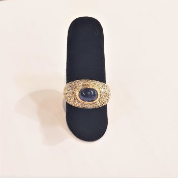 null 18K (750) gold dome ring, set with a cabochon sapphire in a circle of round...