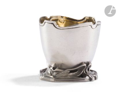 null FRANCE CIRCA 1920
Silver egg cup on ribbons, the scalloped edge molded with...