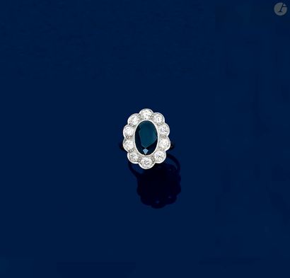 null Bague en platine, ornée d’un saphir de forme ovale entouré de 10 diamants ronds...