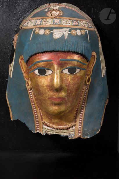 null Mummy mask representing a woman with a golden complexion
She is wearing a blue...