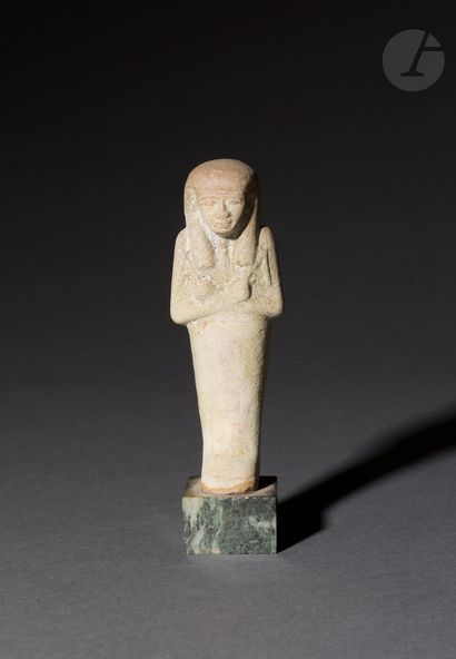 null Oushebti holding his instruments and wearing a tripartite wig
The inscription...