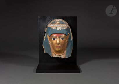 null Mummy mask representing a woman with a golden complexion
She is wearing a blue...