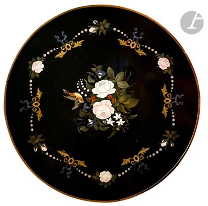 null Table with circular top in hard stone decorated with flowers on a black background...