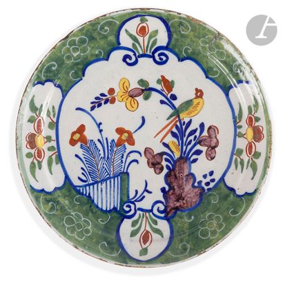 null DELFT 
Assiette calotte en faïence à décor polychrome d'un oiseau perché sur...