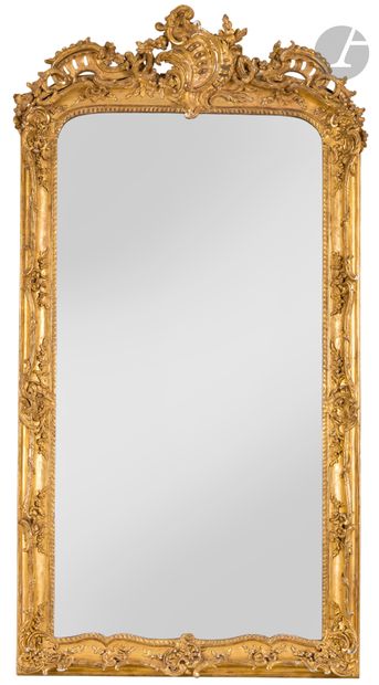 Miroir en bois et stuc doré de forme rectangulaire, à décor de cartouches, feuillages et fleurs, rocailles ajourées et guirlandes.