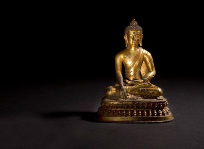 TIBET - XVIE SIÈCLE Statuette de cakyamuni assis sur le lotus en bronze doré, les...