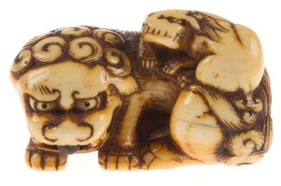 JAPON - Epoque EDO (1603 - 1868) Netsuke en ivoire représentant une chimère couchée,...