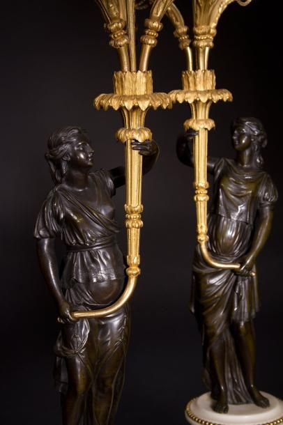 null Paire de candélabres en bronze patiné et doré, les figures de femmes drapées...