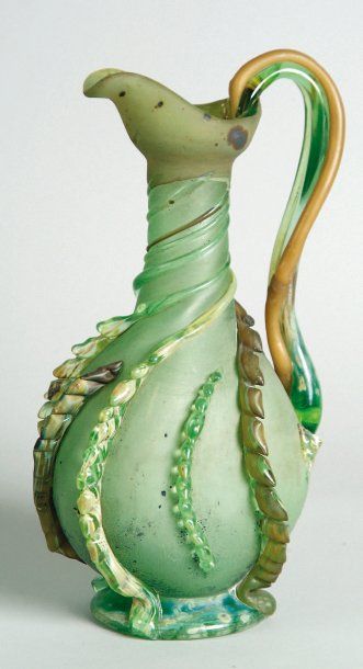 Émile GALLÉ (1846-1904). Broc de style romain en verre vert à décor de torsades appliquées...