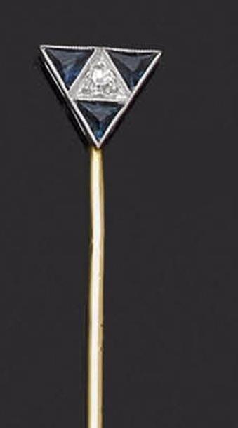 null épingle en or 18K (750‰), sommée d’un triangle serti d’un diamant et de saphirs...