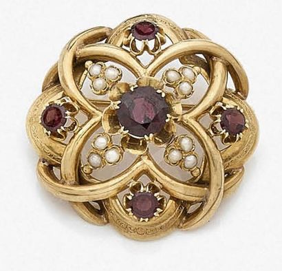 null Broche en or jaune 18K (750‰) formant des entrelacs, ornée de grenats et de...