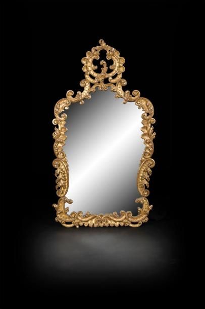null Miroir de forme contournée en bois doré à décor ajouré de rinceaux de feuillage...