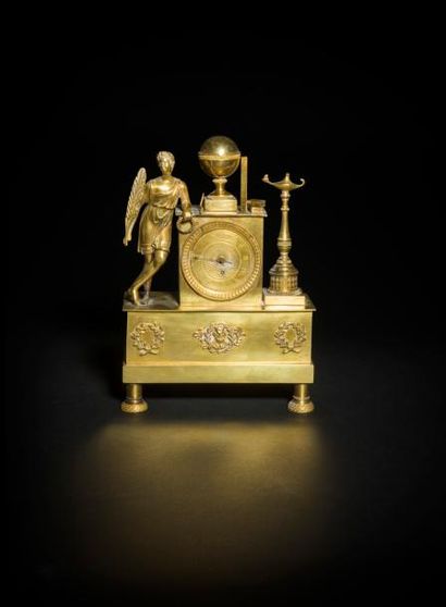 null Petite pendule en bronze doré à décor d’un personnage drapé, sphère et lampe...