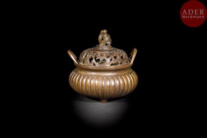 null CHINE - XIXe siècle
Brûle-parfum tripode en bronze à patine brune à anses relevées,...