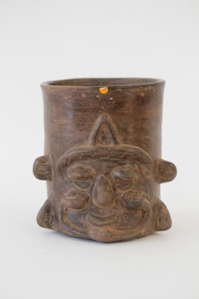 null Vase cylindre décorée de la tête du vieux dieu du feu en relief. Terre cuite...