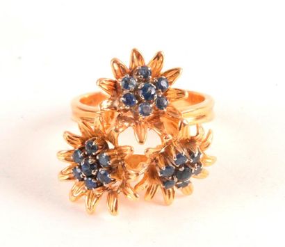 null Bague en or 18K (750 ‰), ornée de trois fleurs, les pistils sertis de saphirs....