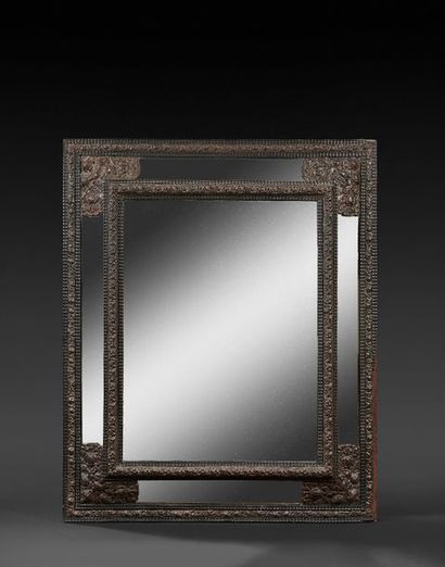 null Miroir en ébène et cuivre repoussé, à décor de feuillages dans les écoinçons...