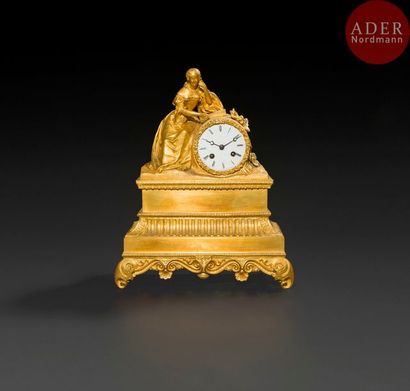  Pendule en bronze doré, à décor d’une femme accoudée au cadran à chiffres romains,...