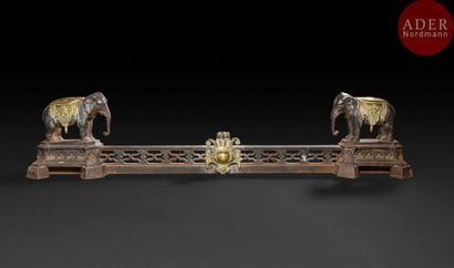  Barre de cheminée aux éléphants en bronze patiné et doré, à décor ajouré et cartouche...