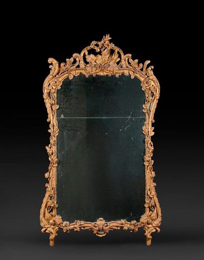 null Miroir en bois doré de forme mouvementée, à décor ajouré de fleurs et feuillages,...