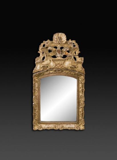 null Miroir en bois doré à fronton ajouré à décor de coquilles et trophées (accidents).
Époque...