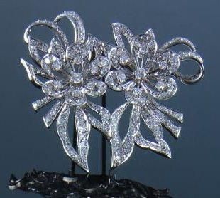 null Clip en or gris et platine stylisant une double fleur ajourée pavée de diamants...