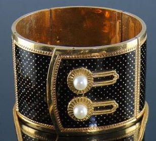 null Bracelet large et articulé à décor de ceinture en or jaune émaillé noir, le...