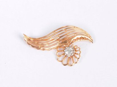 null Broche en or 18K (750) dessinant une courbe agrémentée d'une fleur stylisée...