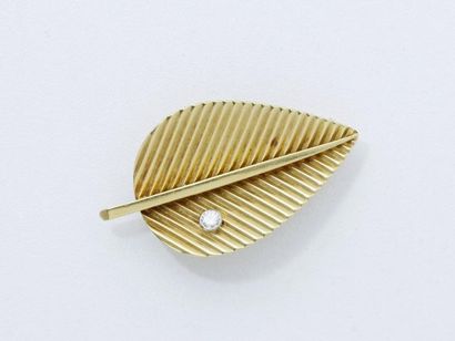 null Broche en or 750 millièmes, stylisant une feuille rainurée ponctuée d'un diamant...