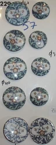null Une plaque comprenant 4 grands boutons en porcelaine peinte à motifs floraux...
