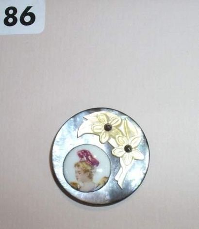 null Un bouton en nacre grise orné en applique d'un médaillon en porcelaine
(D31mm)...