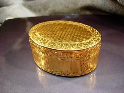 null Boîte ovale en or jaune à décor finement guilloché de rinceaux et rubans sur...