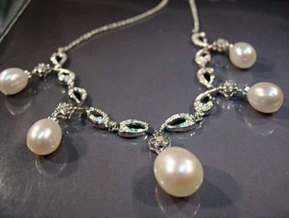null Collier draperie en or gris à festons sertis de diamants retenant des perles...