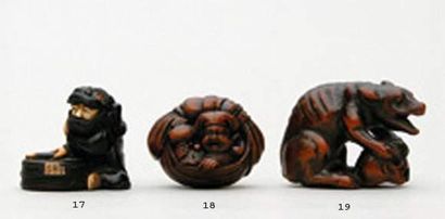 null NETSUKE en bois représentant un loup assis, les pattes posées sur un crâne,...