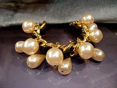 null CHANEL , bracelet rigide ouvert chaîne dorée, lacet de cuir et perles rondes...