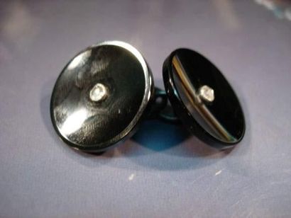 null BOUTON DE MANCHETTE EN ARGENT orné de deux disques d'onyx centrés d'un diamant...