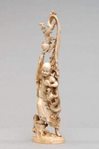 null OKIMONO en ivoire représentant un homme debout portant la perle sacrée, un dragon...
