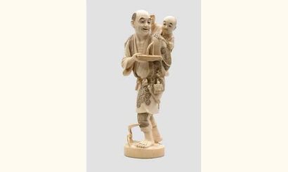 null OKIMONO en ivoire représentant un homme portant sur son dos un bébé et son jouet...