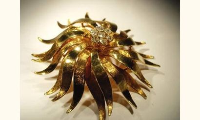 null Broche en or jaune stylisant un dahlia, le cœur pavé de diamants.
Vers 1950....