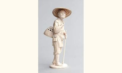 null OKIMONO en ivoire représentant un chasseur coiffé d'un large chapeau, portant...