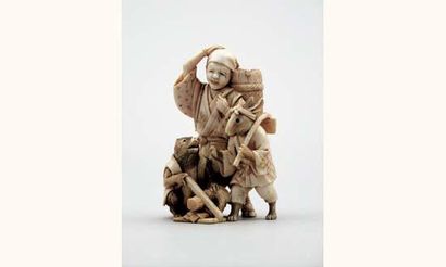 null Okimono en ivoire sculpté et gravé représentant un jeune bûcheron debout accompagné...