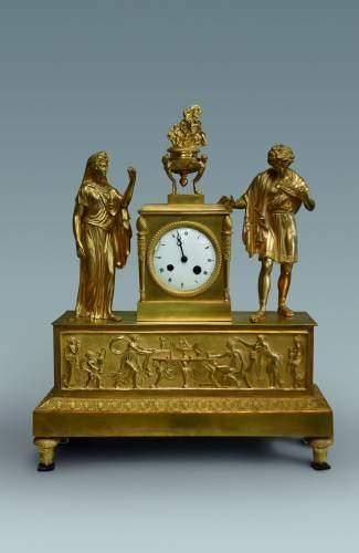null Pendule en bronze doré ciselé, le cadran accosté de deux personnages à l'Antique...