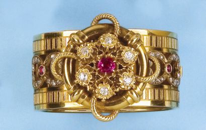 null Bracelet rigide ouvrant en or jaune orné de diamants et de pierres rouges. P....
