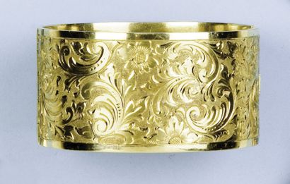 null Large bracelet rigide ouvrant en or jaune ciselé de motifs floraux. P. 200g...