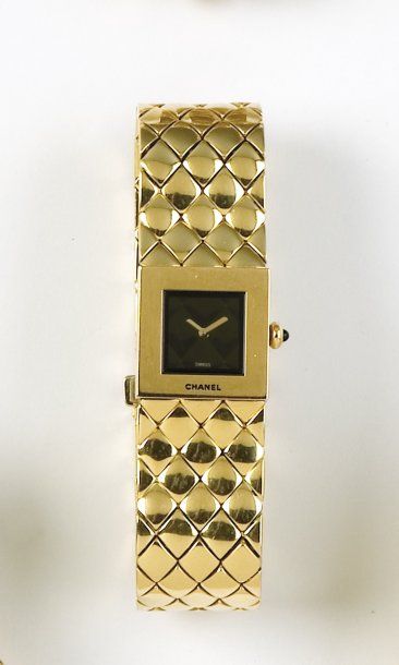 CHANEL "MATELASSEE". Bracelet montre de dame en or jaune. Cadran noir matelassé....